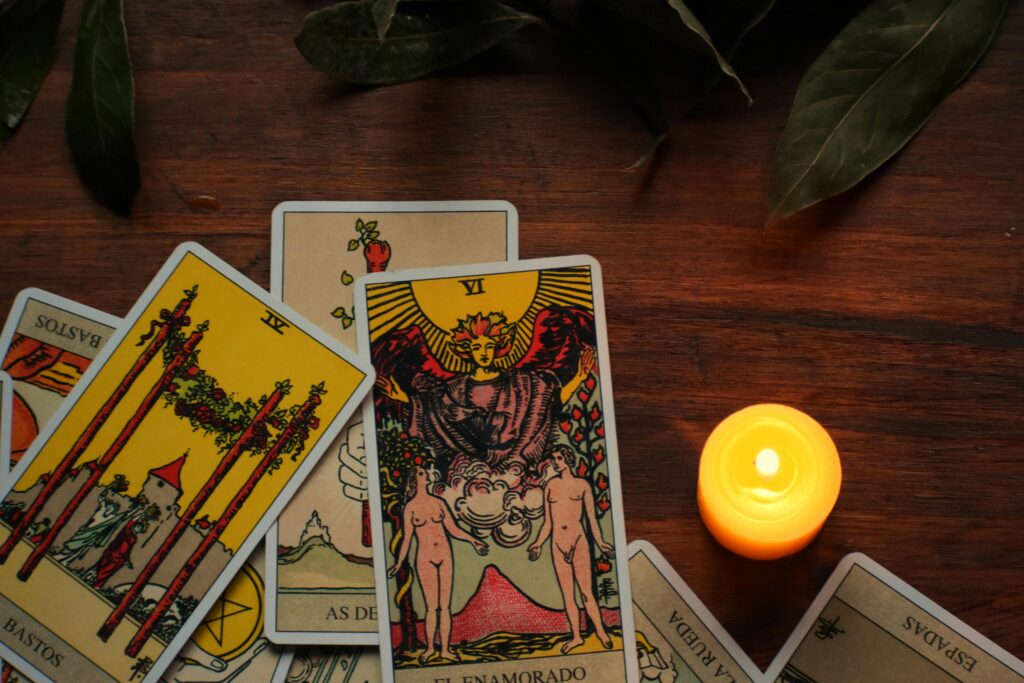 A mystical arrangement of tarot cards with a burning candle creates an ambiance for fortune telling.